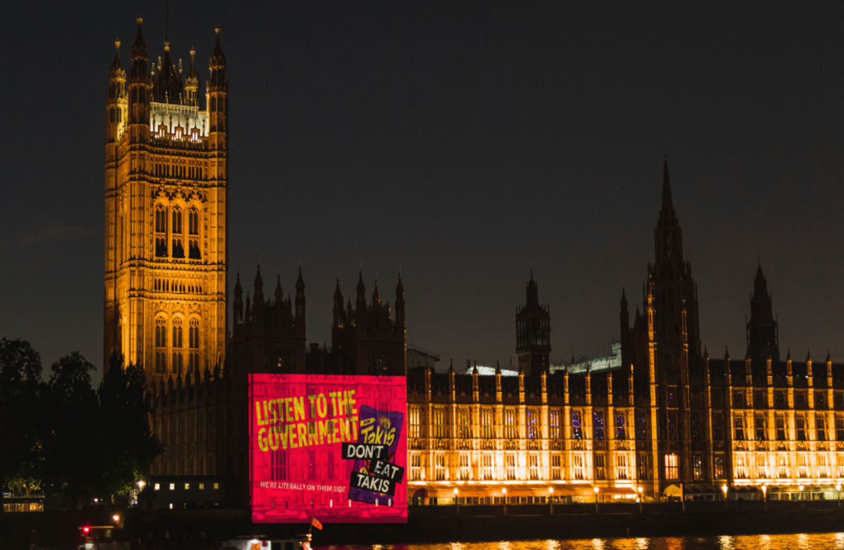 Takis advert projected onto the Houses of Parliament
